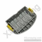 A grey plastic battery door component for a Trimble R4 or R6 GNSS receiver, featuring yellow locking tabs.