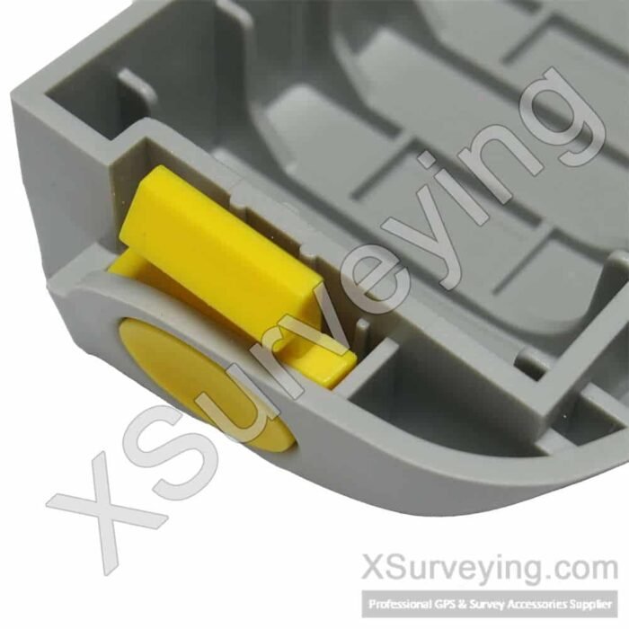 Trimble R4 and R6 Battery Door Replacement Close-up of a grey plastic battery door component with a yellow latch mechanism for a GNSS receiver.